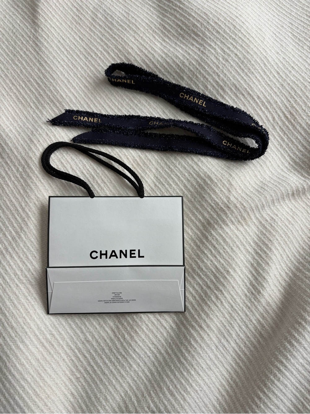 CHANEL Black Ribbon with Gold Logo and Mini White Bag